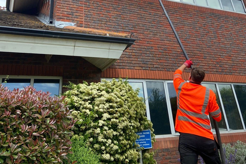 Gutter Being Cleaned with Long Pole